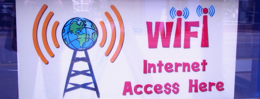 A radio tower with a globe on top and movles to indicate broadcasting, text says  and a WIFI Internet Access
